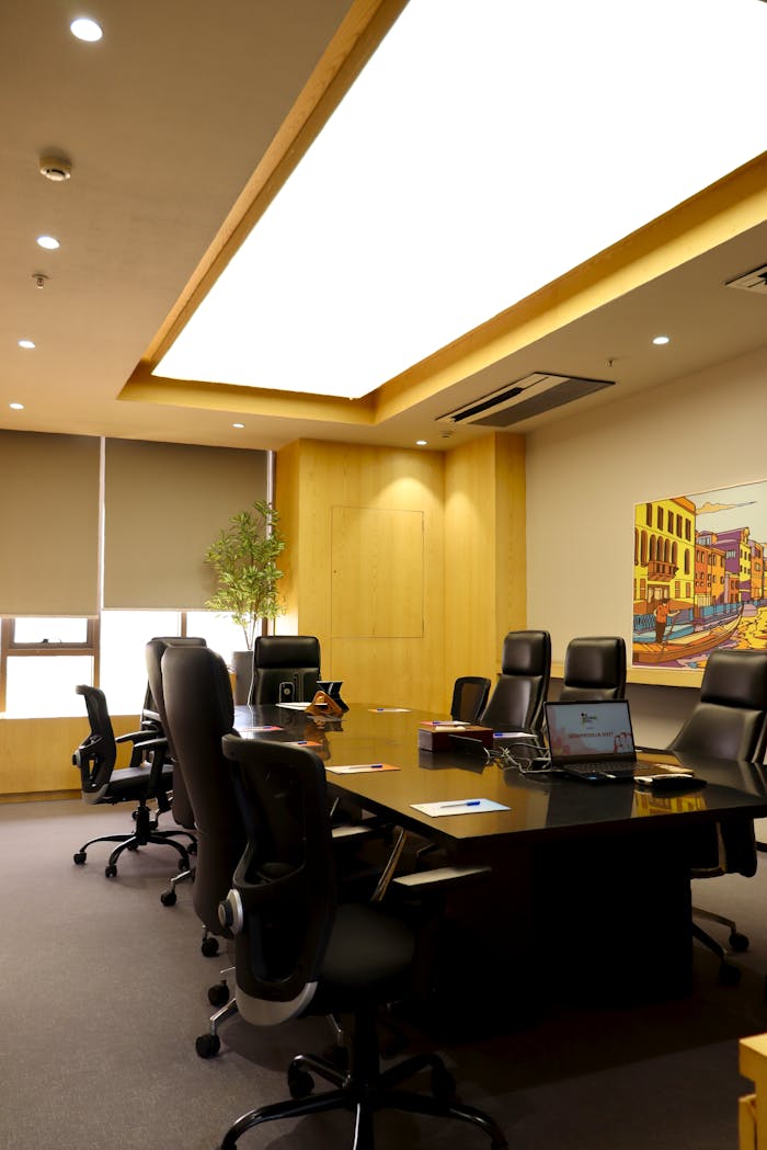 Spacious, well-lit conference room with ergonomic chairs and a sleek table, ideal for meetings.